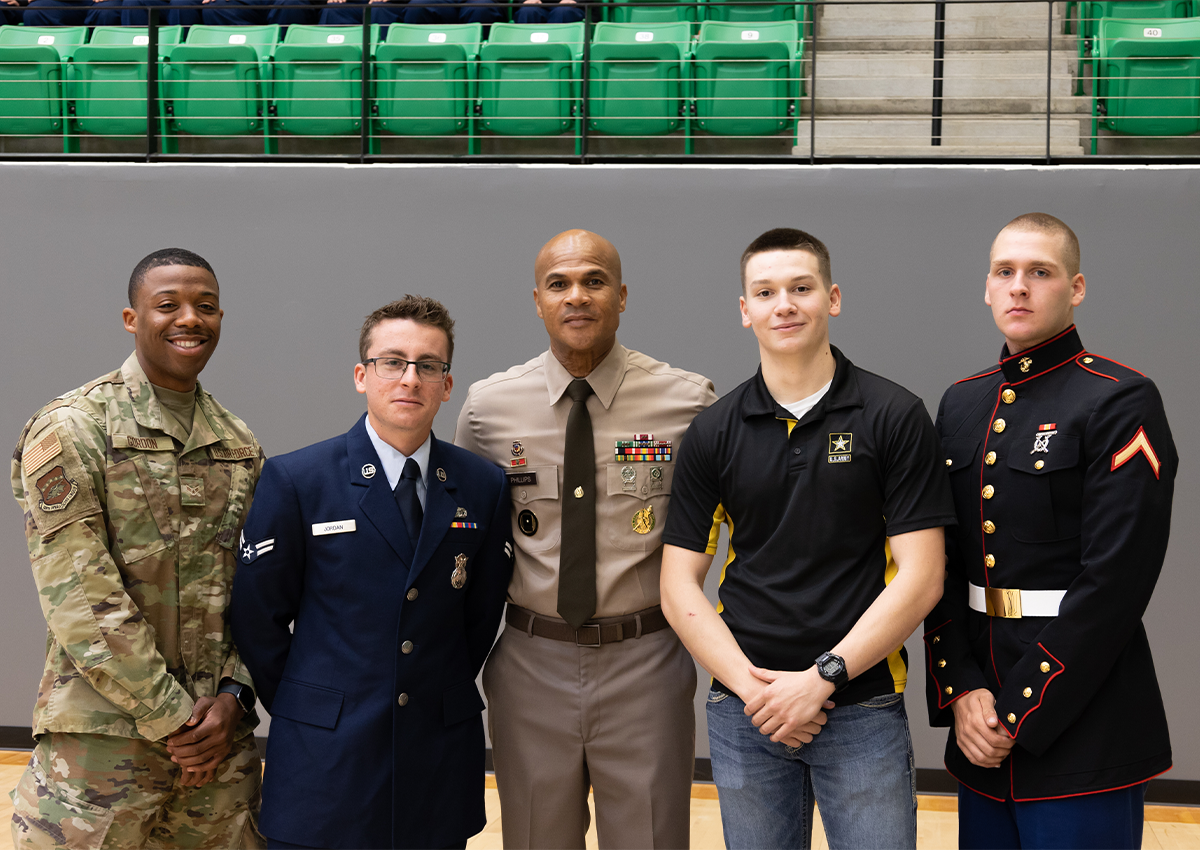 1SG poses with four of his former students, who all have joined a branch of the military. (from left to right: Airman First Class Gordon, 188th Air National Guard, Airman First Class Jordan, Active Duty Airforce, PFC Sebo, Active Duty Army, and Private First Class Davis, Active Duty Marines)