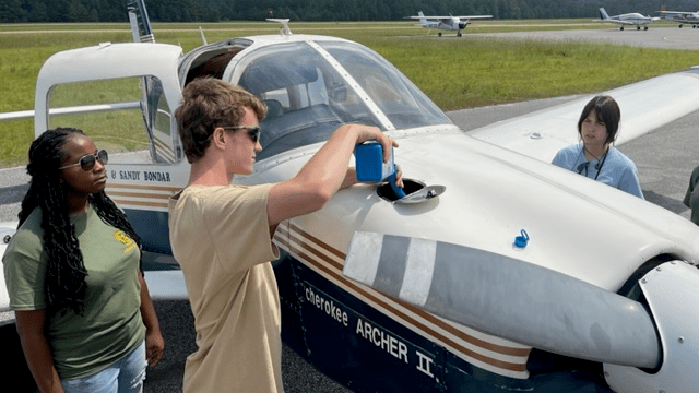 Cadet Austin Irvin places engine oil into single engine aircraft prior to their flight.