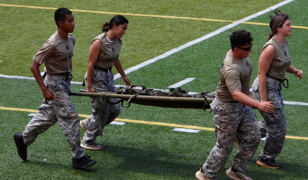 Mixed team running 200 yards for the Casualty Carry Litter Obstacle Course. Right Front Cadet Captain Alexander Cramer, Left Front, Cadet First Sergeant Josephine Camacho, Rear right, Cadet Captain Zurell Jackson, and Rear Left, Cadet Captain Kayley Morimoto.