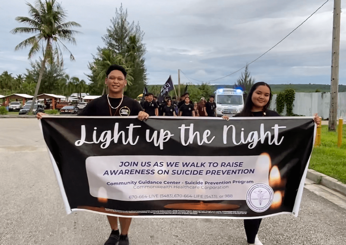 C/1SG Abiel Erickson and C/MAJ Ysabella Palacios holding up the Light Up the Night sign as they lead.