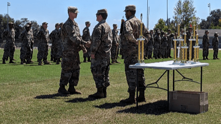 Cadet John Sander getting the Rope Bridge trophy from Cadet Jacob Maley and Cadet Aiden McPhadden during the award ceremony of the competition.