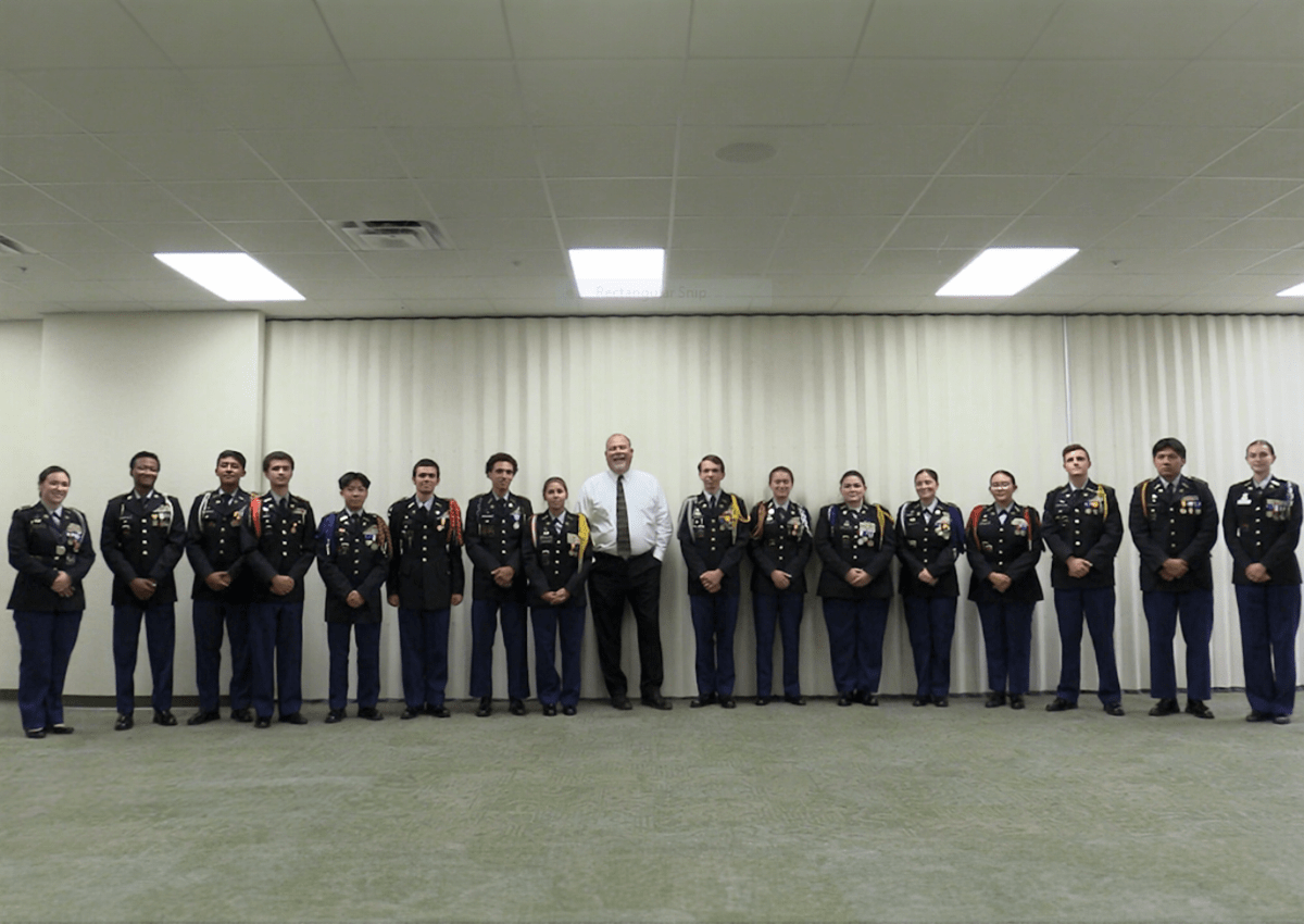 The Superintendent Dr. Christopher Bernier poses with the JROTC Programs Commanders of Lee County while filming his promotional message.