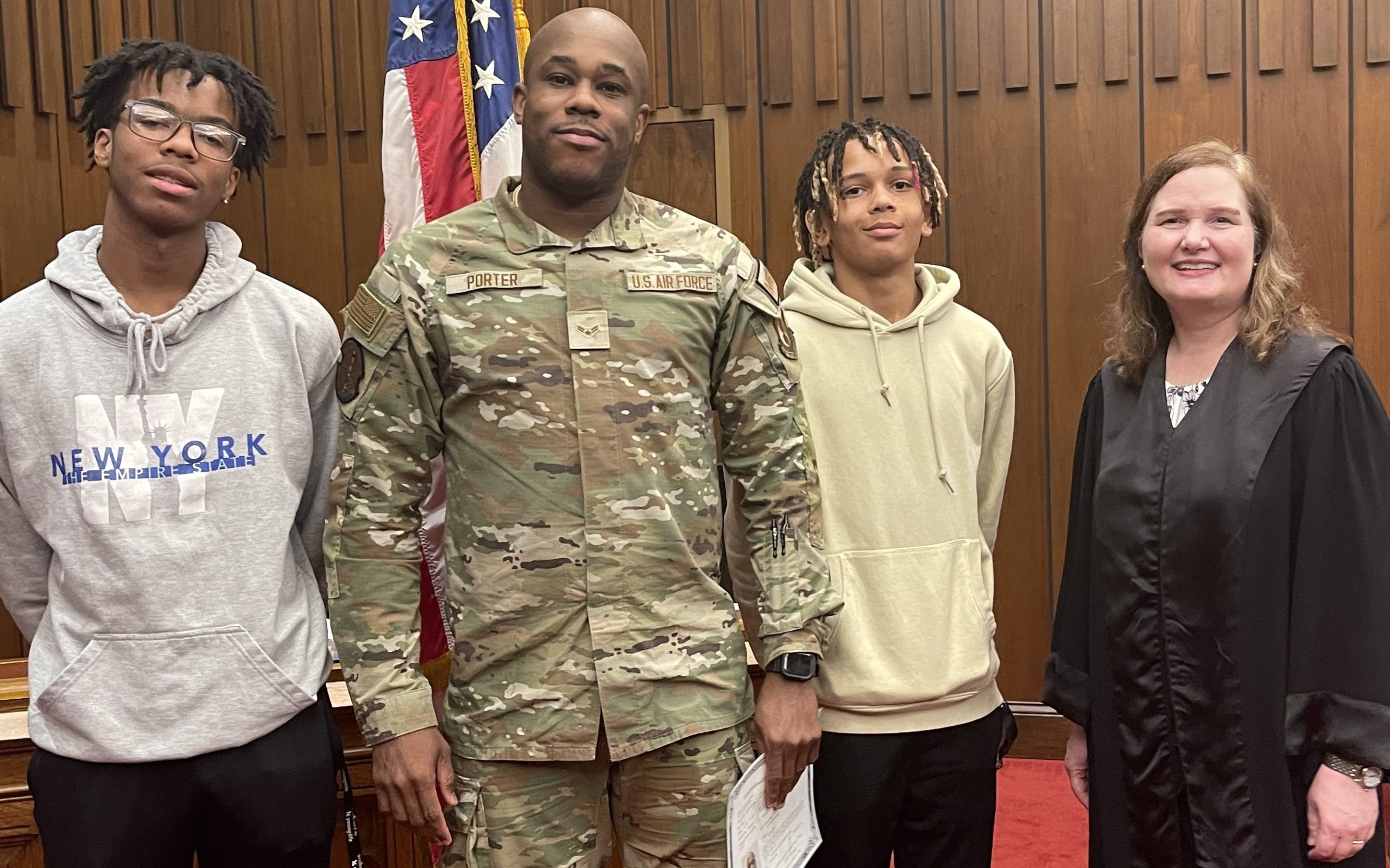 Cadets Shamore Stacey and Damon Murdock flanking newly naturalized US citizen from Latin America with Judge Gentry (R)
