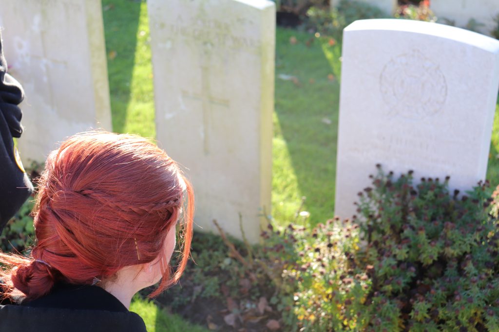 Cadet Moseley reading a tombstone at Essex Farm Cemetery.