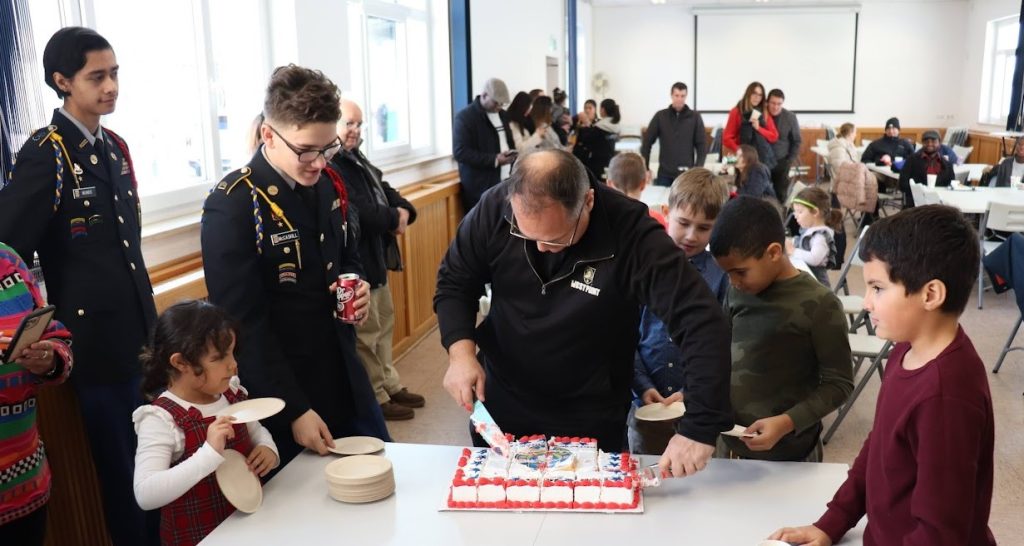 Father Paul serves cake to parishioners.