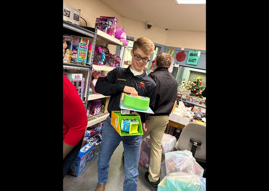 (Photo Credit: Cadet CPT Mike Jusko, Bn S5/PAO) Cadet Major Mike Nicastro gathering toys at the Toys For Tots warehouse!