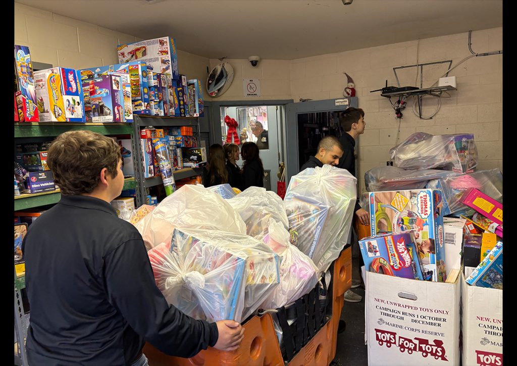 (Photo Credit: Cadet LET 2 Mike Stanton, LET 2 Marc Nagtegaal and LET 3 Nathan Ortiz moving carts full of donated toys, getting ready to bag them up for local families!