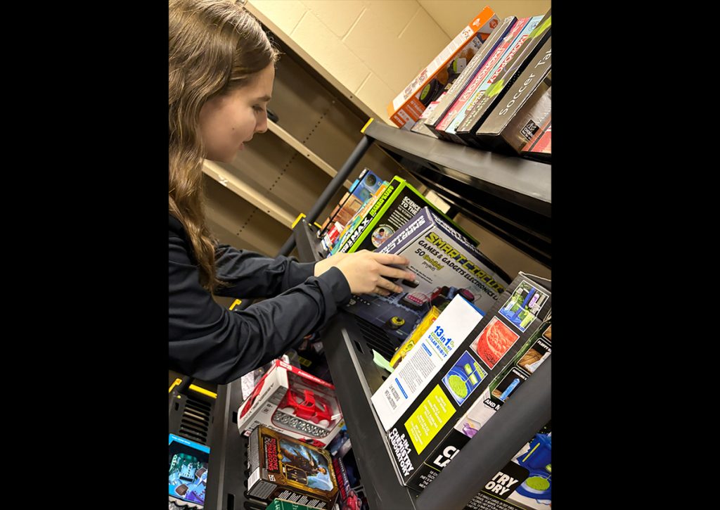 (Photo Credit: Cadet LET 2 Chloe Valentino selecting a toy at the Toys For Tots warehouse for a local family! We hope it brings them some holiday joy!