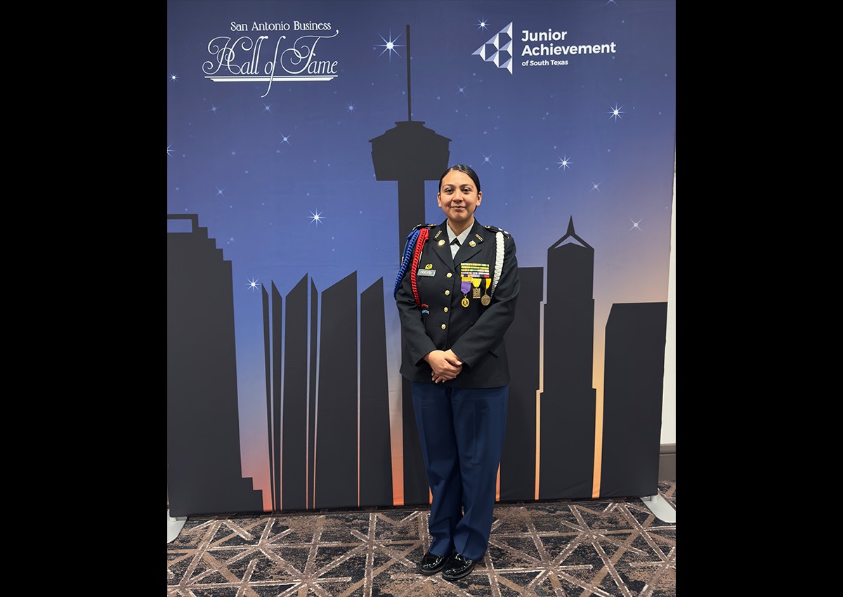IMG-3110: C/LTC Huerta posing in front of the Junior Achievement SA Business Hall of Fame Fundraising dinner backdrop on March 18, 2025.